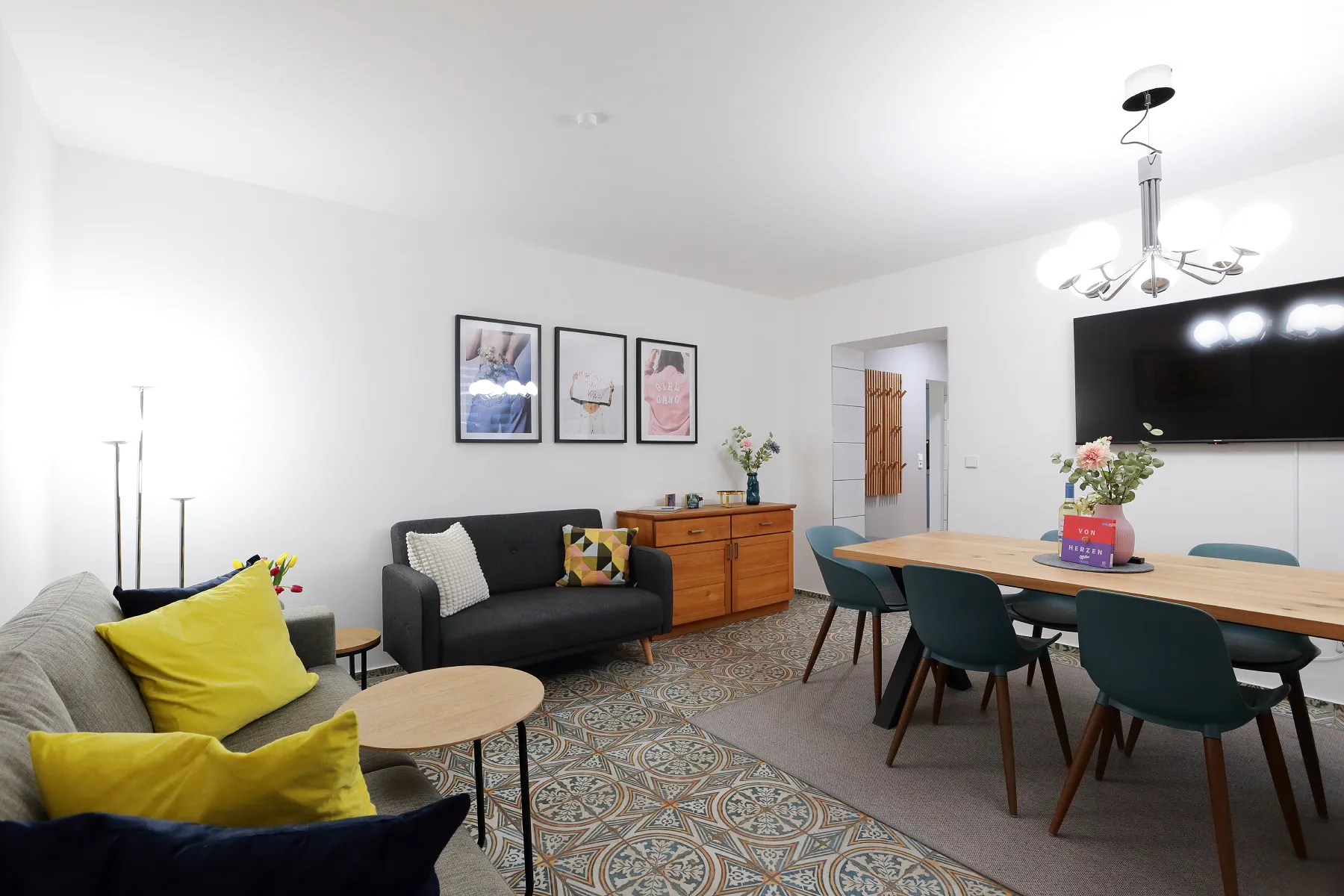 Großzügiger Wohn- und Essbereich des N15 Apartments mit Sofa, großem Esstisch und Fernseher