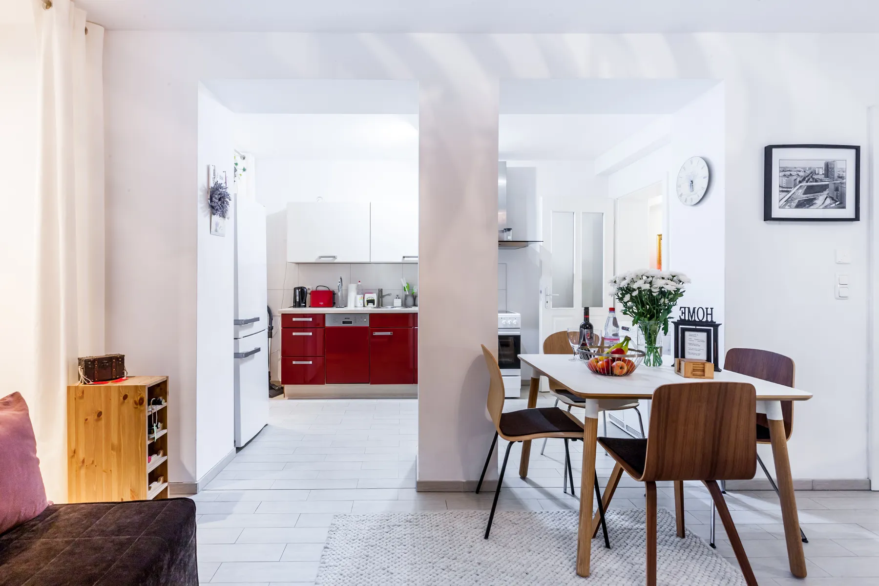 Heller Essbereich des S31 Back Apartments in der Bergmannstraße mit Blick zur roten Küche